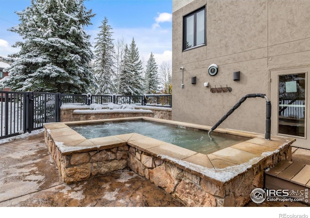 snow covered pool with an in ground hot tub