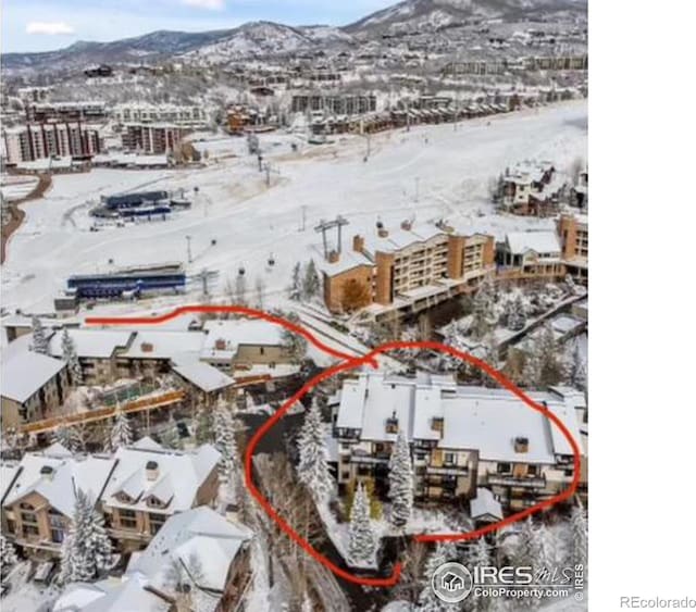 snowy aerial view featuring a mountain view