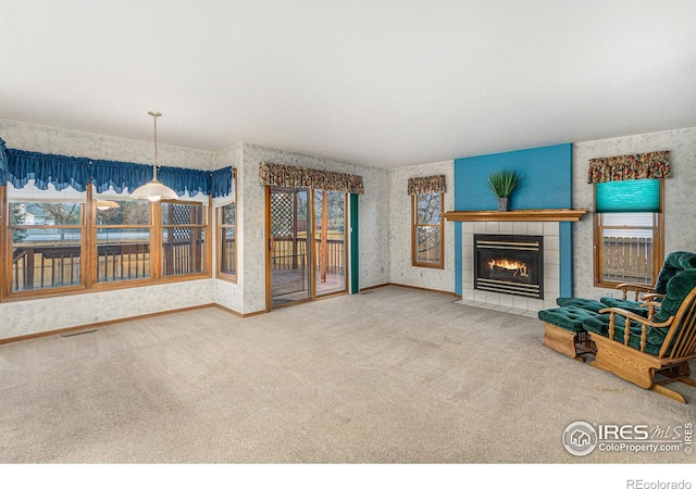 unfurnished living room with carpet and a fireplace