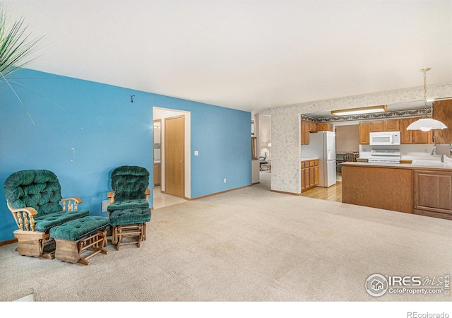 living area featuring sink and light carpet