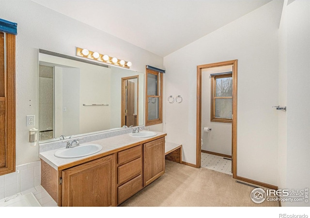 bathroom featuring toilet, vanity, and lofted ceiling