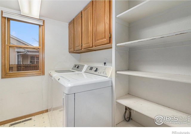 laundry area with washing machine and dryer and cabinets