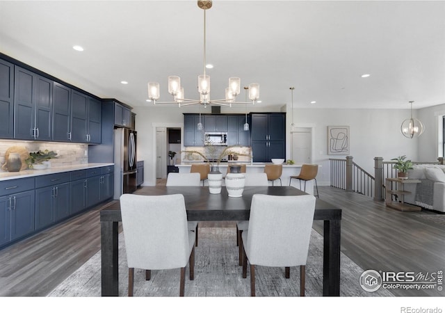 dining area with dark wood-type flooring and a notable chandelier