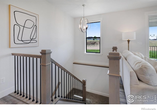 stairs with a notable chandelier