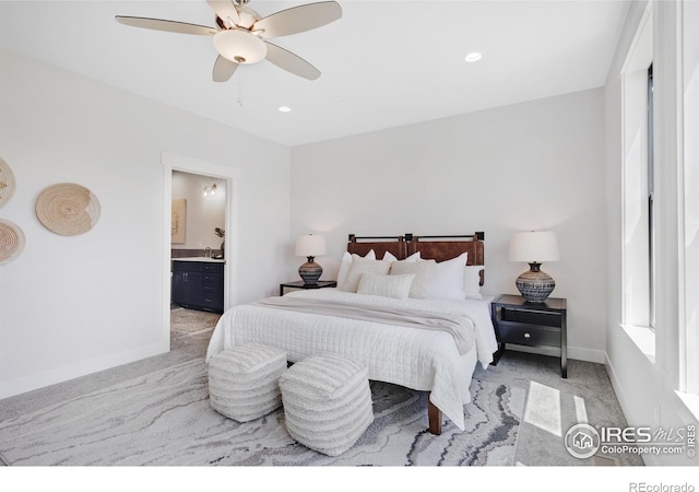 bedroom with light colored carpet, ceiling fan, and ensuite bathroom