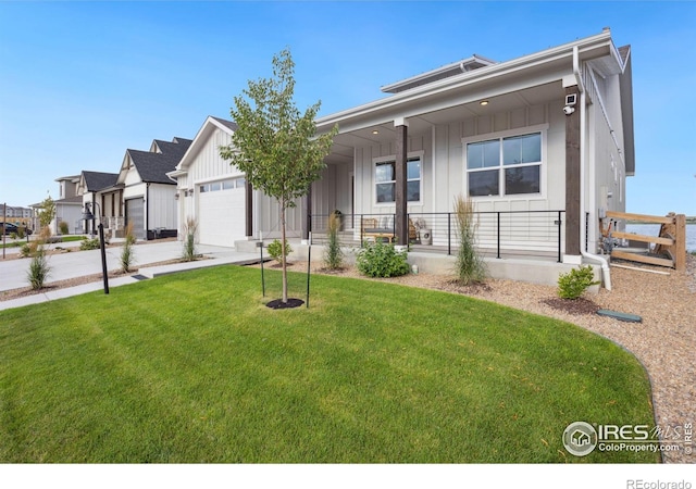 view of front of home featuring covered porch, a garage, and a front yard