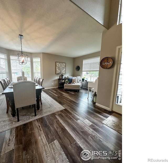 dining room featuring dark hardwood / wood-style flooring, a textured ceiling, and a chandelier