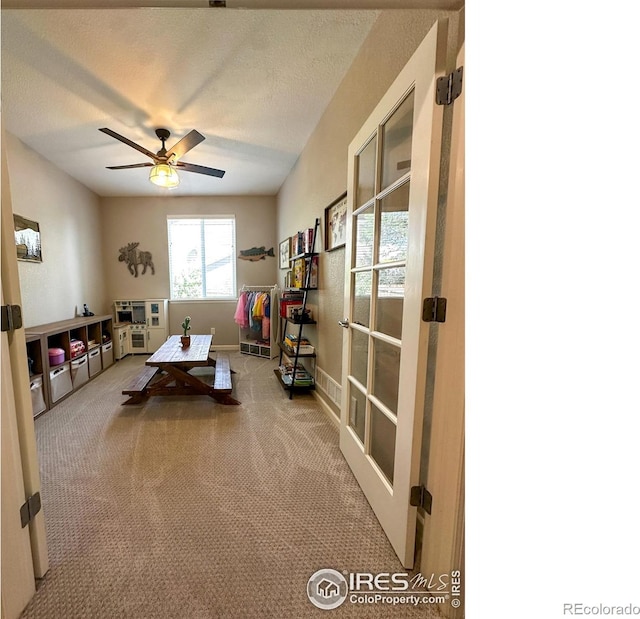 rec room with ceiling fan, a textured ceiling, and carpet flooring