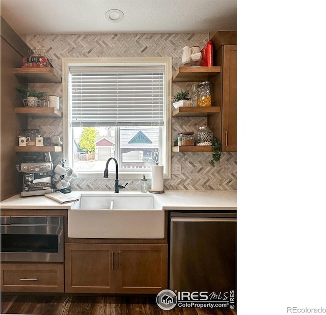 kitchen featuring stainless steel dishwasher, dark hardwood / wood-style floors, and sink