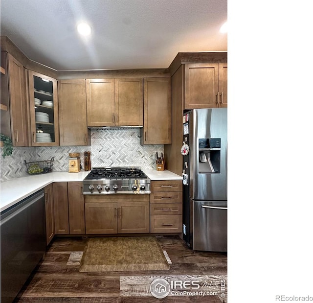 kitchen featuring dark wood-type flooring, tasteful backsplash, and stainless steel appliances