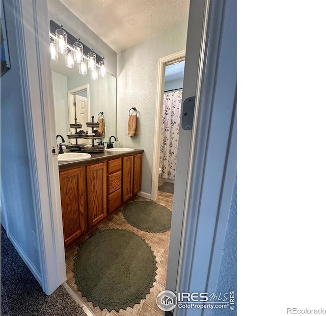 bathroom featuring toilet, vanity, a textured ceiling, and a shower with shower curtain