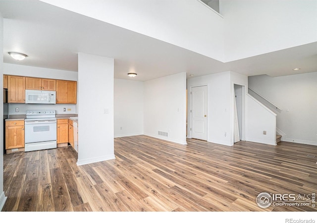 kitchen featuring dark hardwood / wood-style flooring, a high ceiling, and white appliances