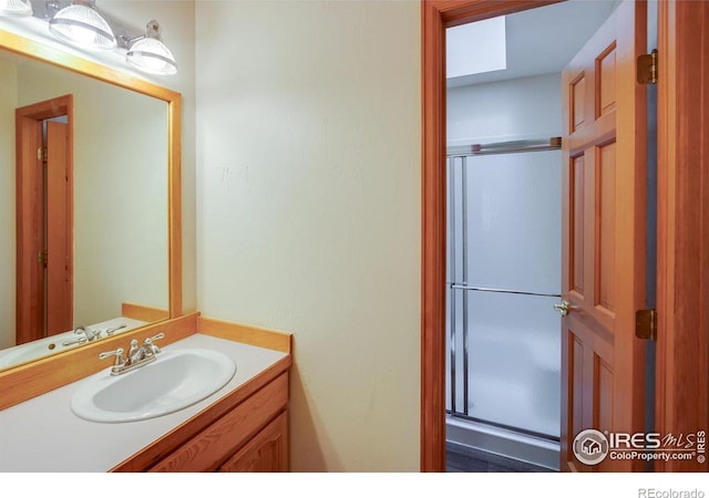 bathroom with vanity and a shower with door