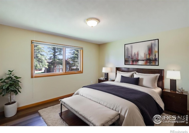 bedroom with dark hardwood / wood-style floors