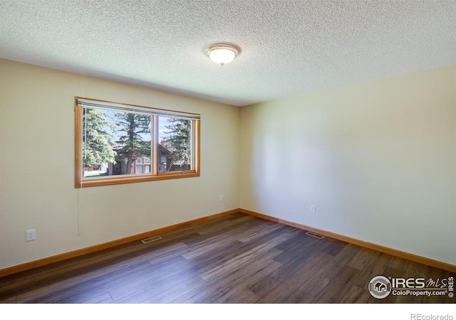 unfurnished room featuring dark hardwood / wood-style floors and a textured ceiling