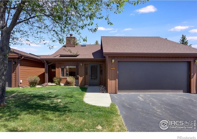 single story home featuring a front lawn and a garage