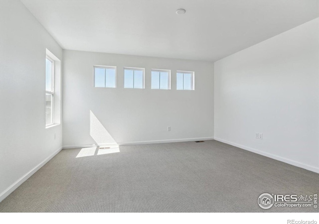 carpeted empty room featuring plenty of natural light