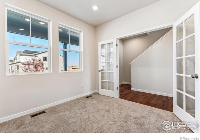 empty room with french doors and dark carpet