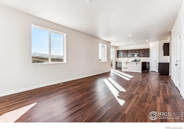 unfurnished living room with sink and dark hardwood / wood-style flooring