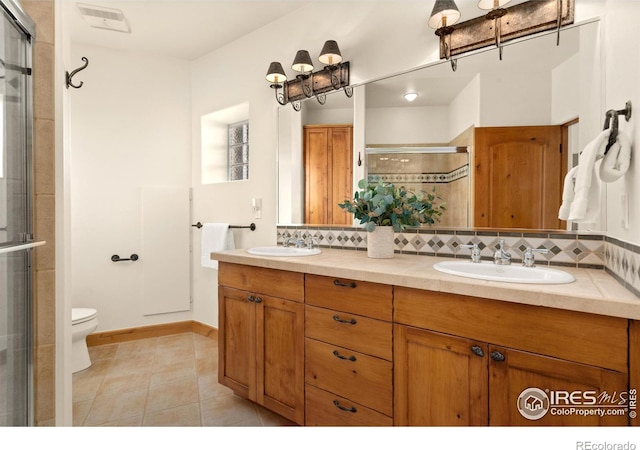 bathroom featuring decorative backsplash, tile patterned floors, an enclosed shower, vanity, and toilet