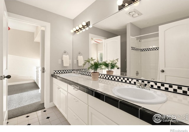 bathroom with tiled shower, vanity, and tile patterned floors