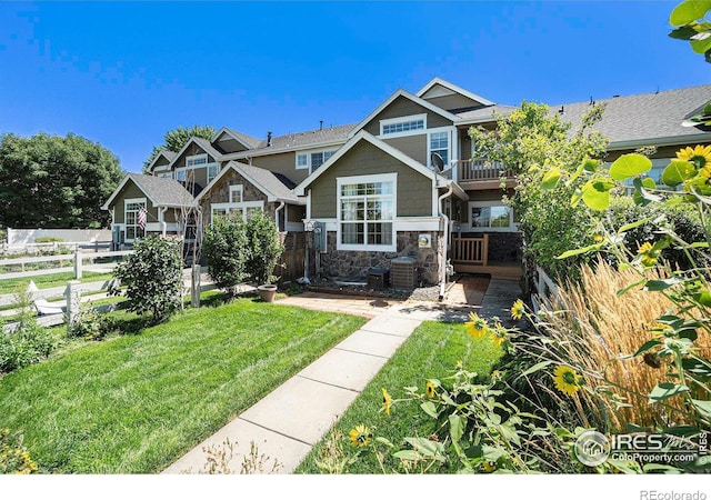 craftsman house with a balcony and a front yard