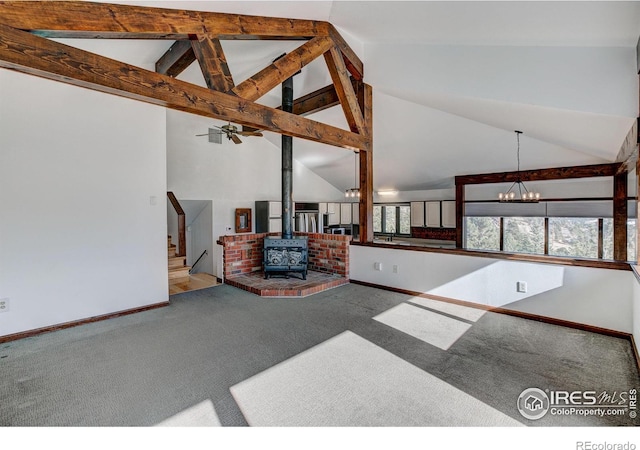 carpeted living room with beamed ceiling, ceiling fan with notable chandelier, high vaulted ceiling, and a wood stove