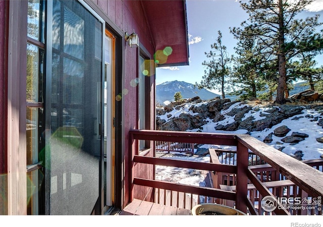 snow covered back of property with a mountain view