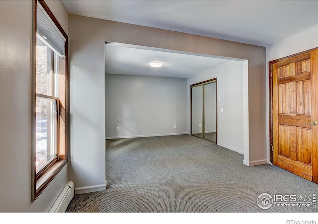 empty room featuring carpet flooring, a wealth of natural light, and a baseboard radiator