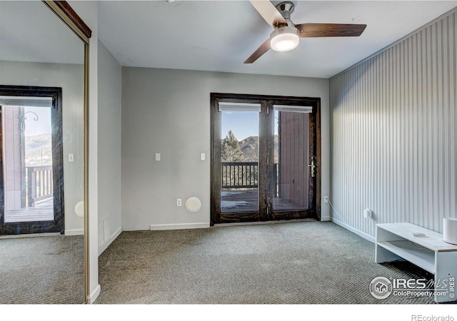 carpeted foyer featuring a wealth of natural light and ceiling fan