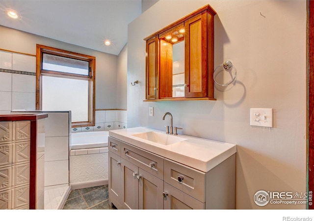 bathroom with vanity and a relaxing tiled tub