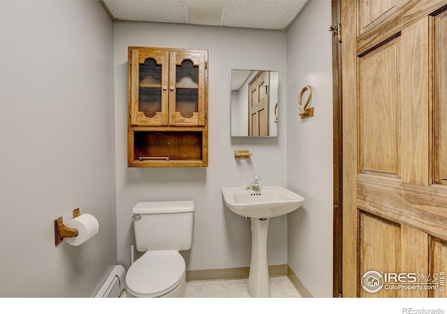 bathroom featuring baseboard heating and toilet