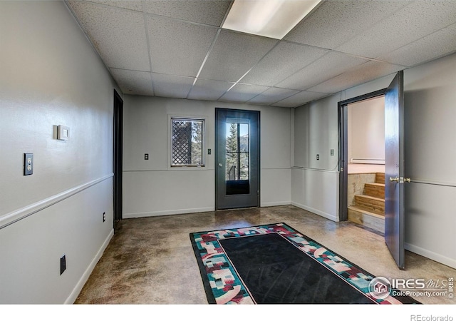 foyer entrance with a paneled ceiling and concrete flooring