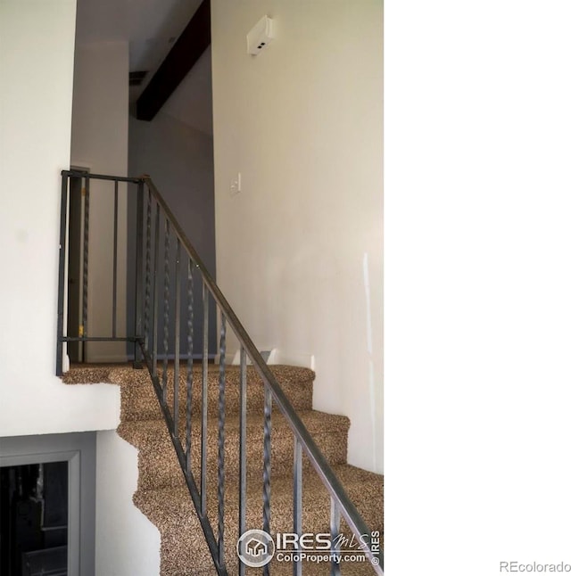 stairway with beamed ceiling