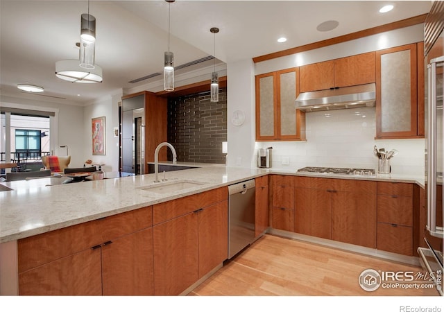 kitchen with sink, stainless steel appliances, kitchen peninsula, light hardwood / wood-style floors, and decorative light fixtures