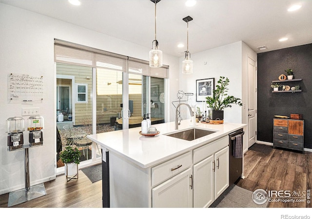 kitchen with dark hardwood / wood-style floors, white cabinetry, stainless steel dishwasher, and sink