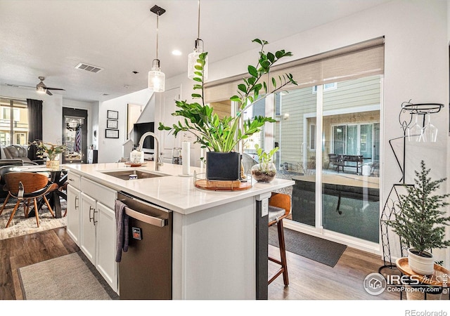 kitchen with sink, dark wood-type flooring, stainless steel dishwasher, a center island with sink, and white cabinets