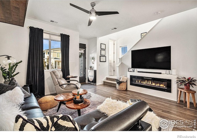 living room with ceiling fan and dark wood-type flooring