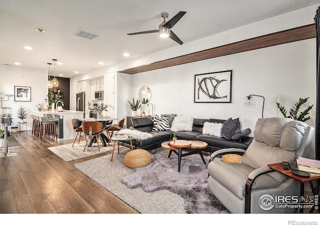 living room with ceiling fan and dark hardwood / wood-style flooring