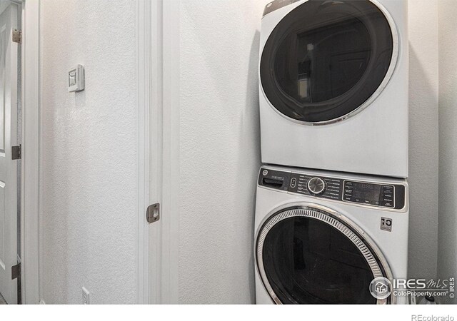 clothes washing area featuring stacked washer / dryer