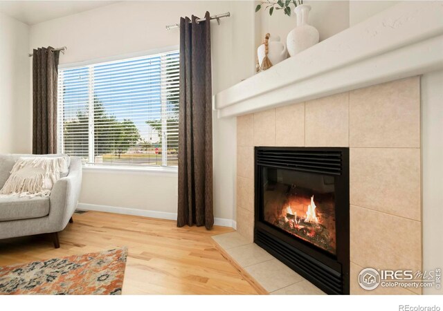 sitting room with wood-type flooring and a tile fireplace