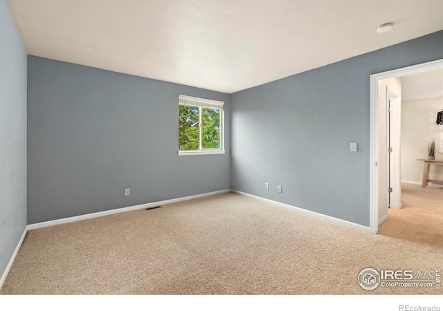 unfurnished room featuring light colored carpet