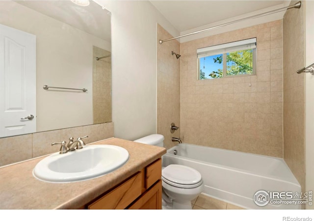 full bathroom featuring tiled shower / bath, tile patterned flooring, vanity, and toilet