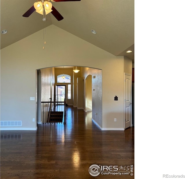 empty room with dark hardwood / wood-style flooring, high vaulted ceiling, and ceiling fan