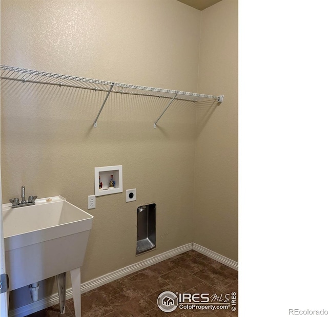 clothes washing area featuring hookup for an electric dryer, washer hookup, dark tile patterned flooring, and sink