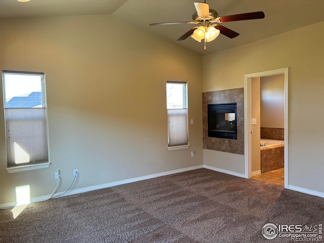 unfurnished living room featuring vaulted ceiling, a wealth of natural light, carpet, and ceiling fan