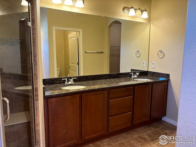 bathroom with tile patterned flooring, vanity, and walk in shower