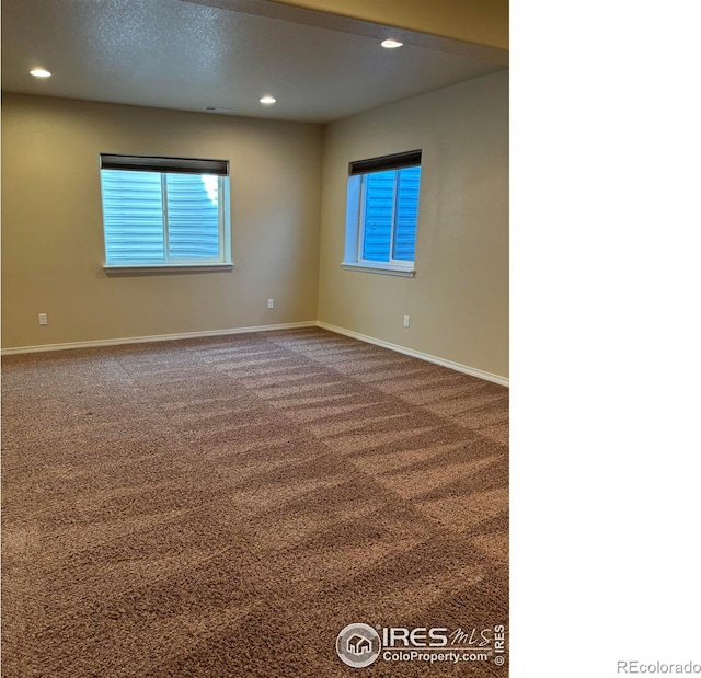 spare room with carpet and a textured ceiling