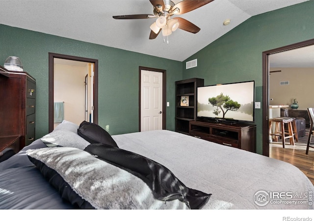 bedroom with hardwood / wood-style floors, ceiling fan, and vaulted ceiling