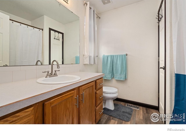 bathroom featuring hardwood / wood-style flooring, vanity, and toilet